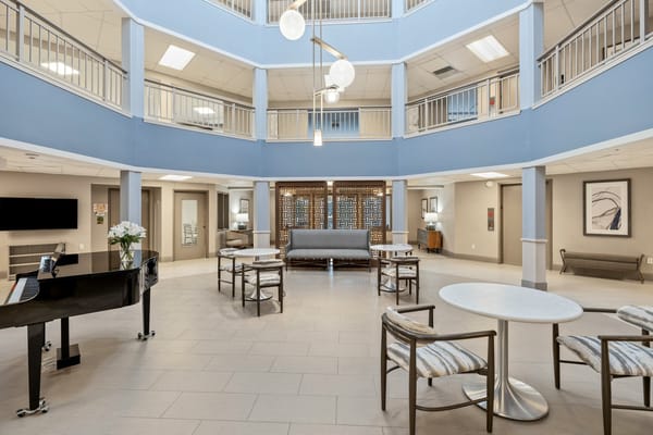 Bright and spacious common area with seating and a piano