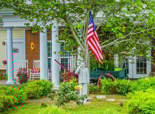 Outdoor area of a senior living community with a statue and flag