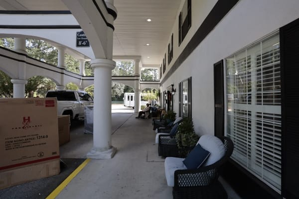 Seating area outside the entrance of Sodalis Jacksonville with potted plants and a resident sitting.