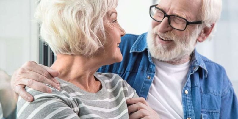 Two seniors smiling while enjoying a conversation