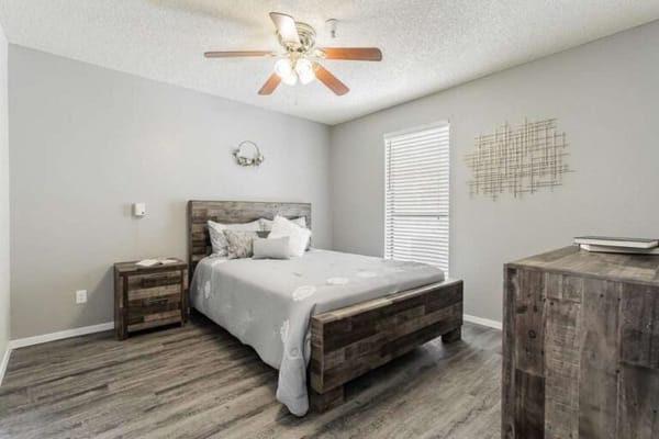 Cozy bedroom setup with a wooden bed and natural light