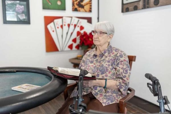 Resident sitting at a common area with playing cards