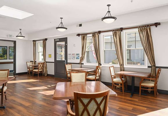 Bright common area with wooden tables and chairs
