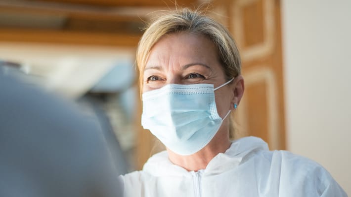 A staff member wearing a mask and smiling