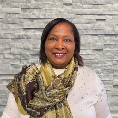Woman smiling in front of a textured wall
