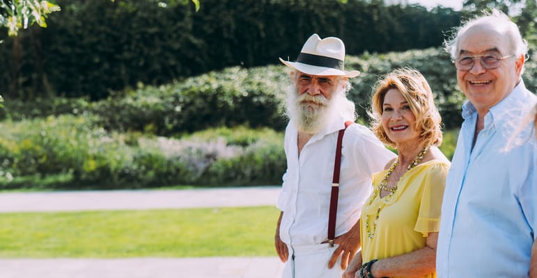 Three seniors smiling in an outdoor setting