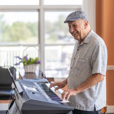 Resident playing keyboard in a lively activity area