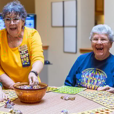 Residents engaging in a bingo activity with a volunteer