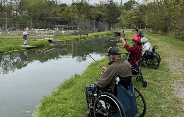 Residents fishing by the pond in wheelchairs
