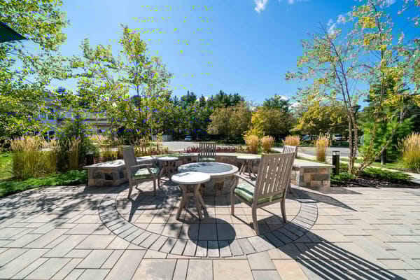 Outdoor seating area with trees and landscaping