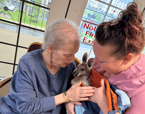 Resident and staff interacting with a small animal