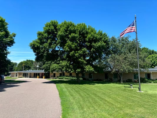 Exterior view of Tuff Memorial Home with trees and flag