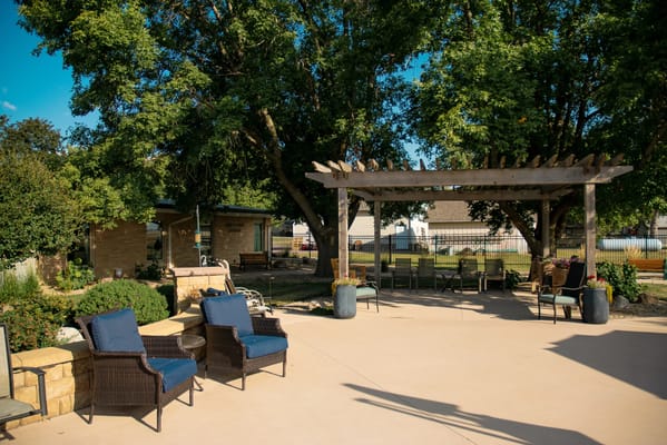 Outdoor patio area with seating and greenery