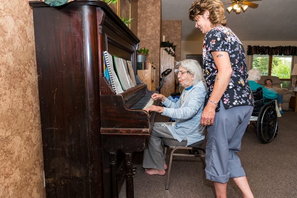 Residents playing piano in a common area
