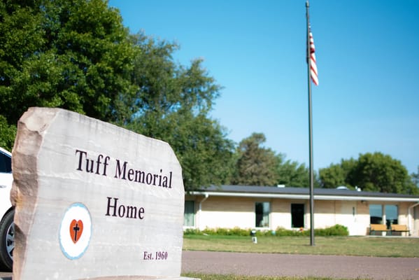 Exterior view of Tuff Memorial Home with sign and flag