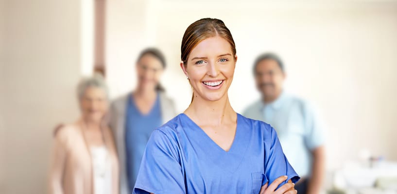 Smiling staff member with residents in the background