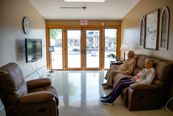 Residents relaxing in a common area with large windows