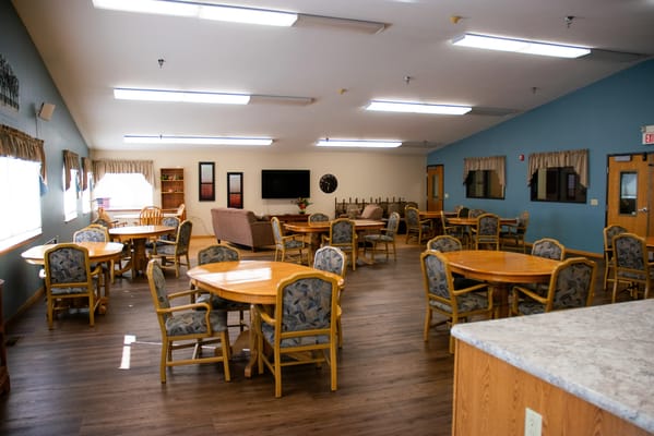 Common area with dining tables and chairs in bright space