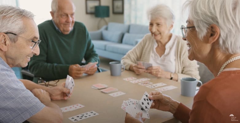 Seniors playing cards in an activity room