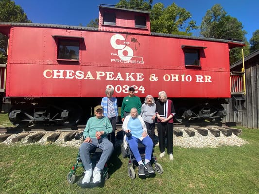 Residents enjoying a day outside next to a historic train car