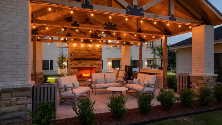 Outdoor seating area with a cozy fireplace and lighting
