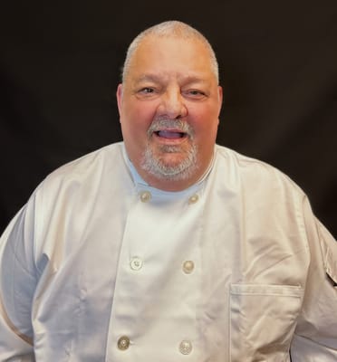 Chef in a white uniform smiling