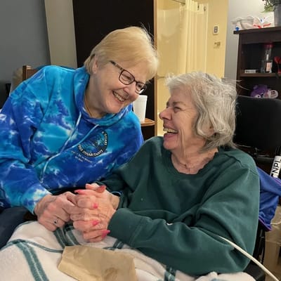 Two residents sharing a joyful moment in a common area