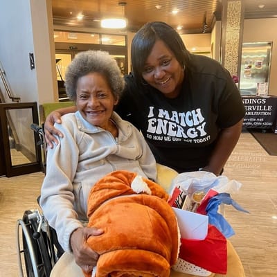 Resident and staff member smiling in a common area