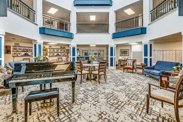 Bright common area with seating and a piano