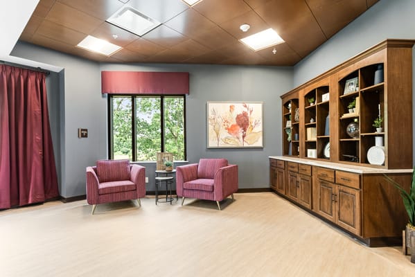 A cozy common area with two chairs and a bookshelf