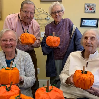 Residents displaying their pumpkin crafts in an activity room