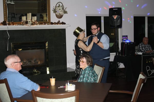 Residents dancing with staff during a celebration