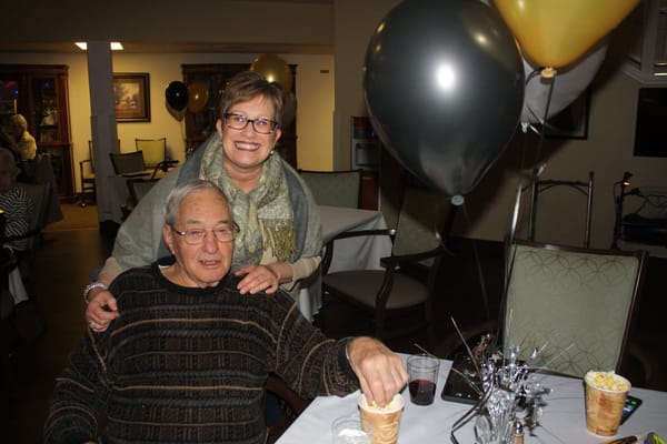 Resident enjoying popcorn at a celebration with staff member