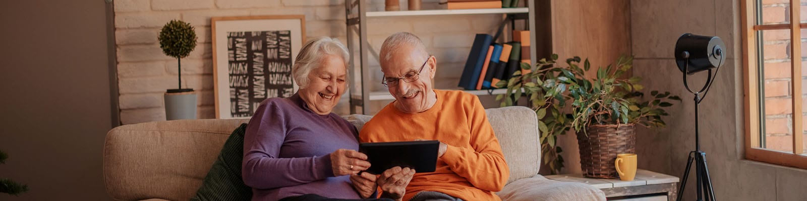 Two smiling residents enjoying a tablet together