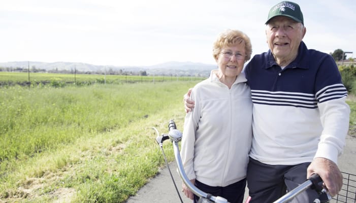 Elderly couple enjoying a bike ride in a scenic area