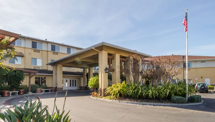 Front entrance of a senior living facility with landscaped surroundings