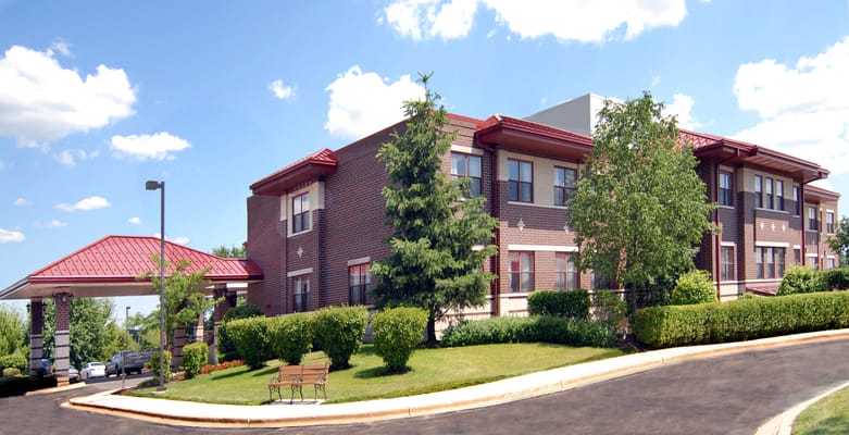 Exterior view of a senior living facility with garden