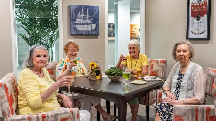 Four residents enjoying drinks in a common area