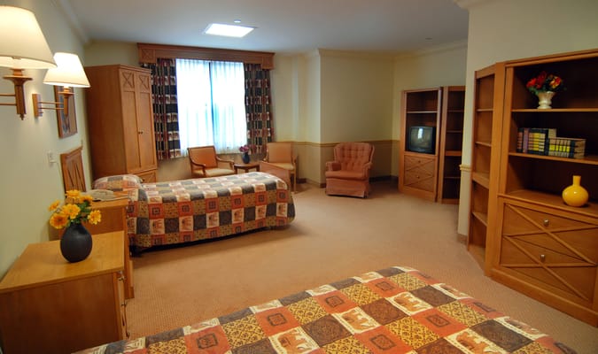 A cozy resident room with two beds and seating area