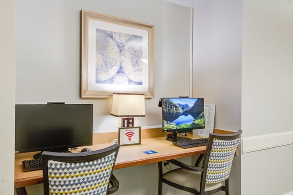 Two desks in a shared work area with computers