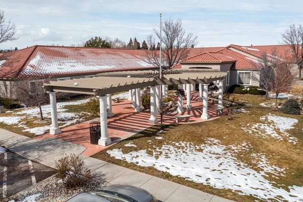 Exterior view of a facility with outdoor pergola and snow