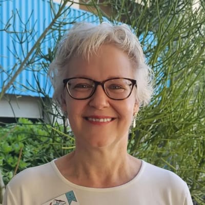 Smiling staff member in a garden setting