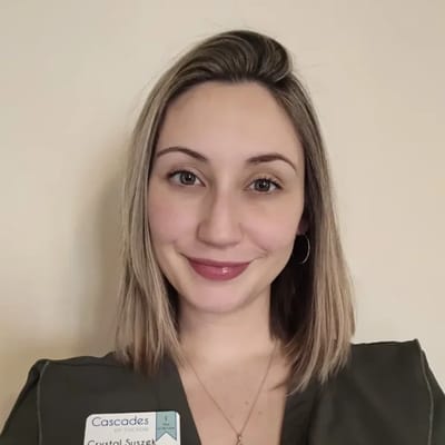 Staff member posing for a photo with name badge