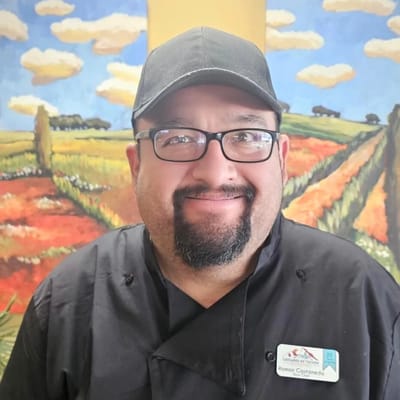 Chef smiling with colorful background mural