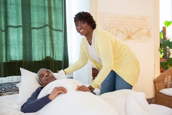 Caregiver assisting a resident in bed