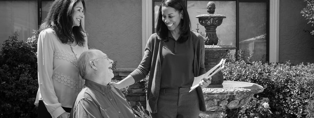 Staff interacting with a resident in a garden area