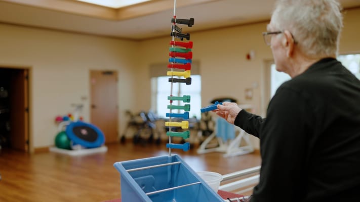 An elderly resident engaged in a therapy activity indoors
