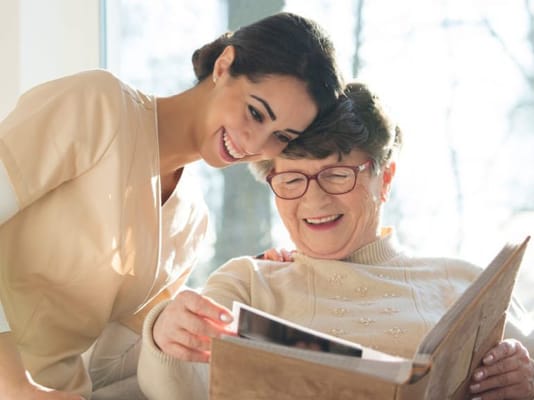 A caregiver and a resident sharing a joyful moment