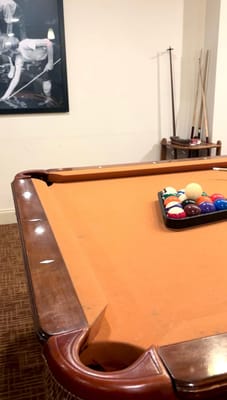 A billiards table set up for play in a common area