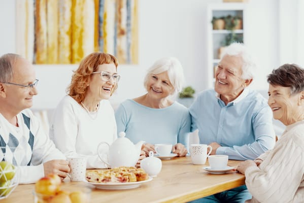 Seniors enjoying tea and pastries in a common area